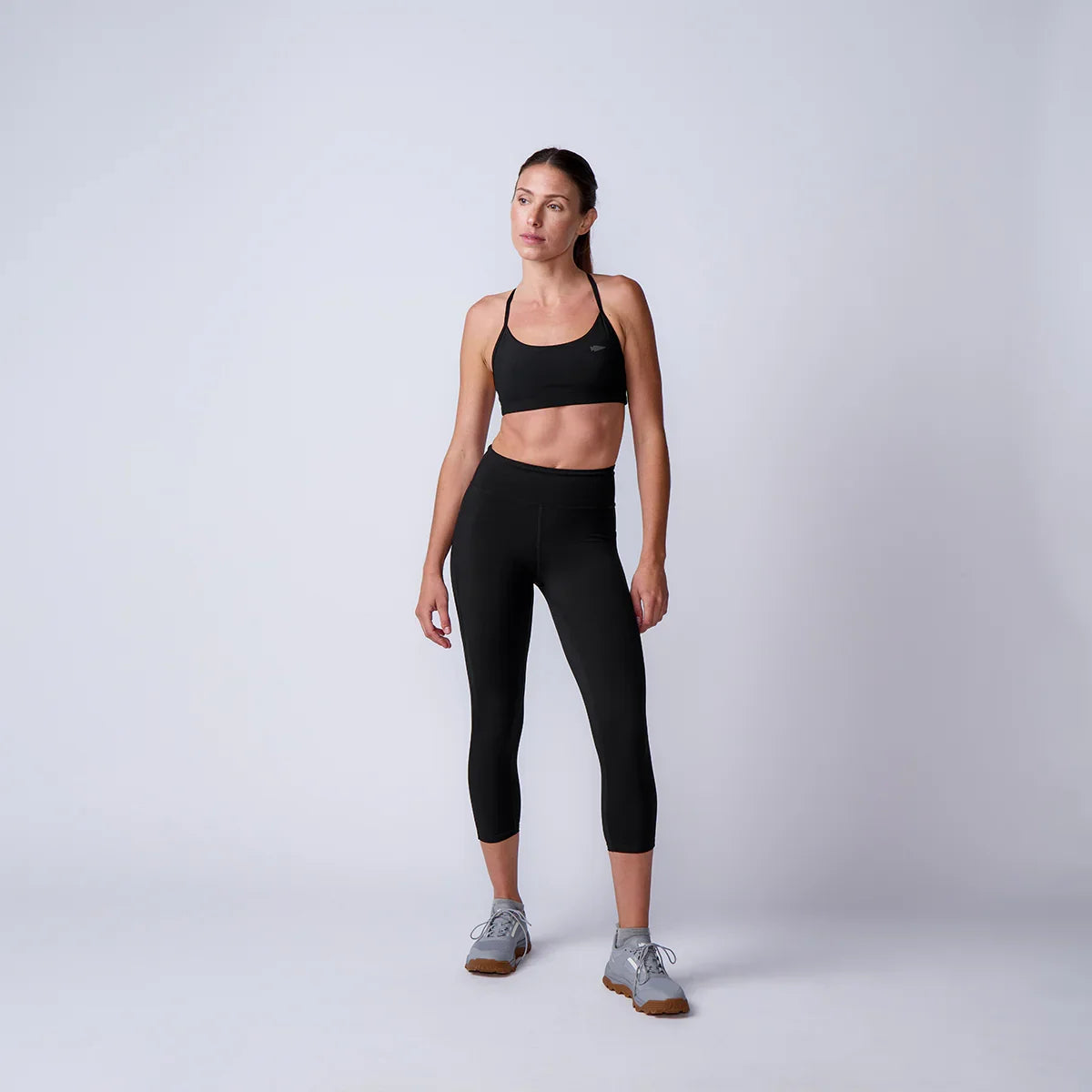 Woman wearing GORUCK black sports bra and leggings, studio rucking gear photoshoot