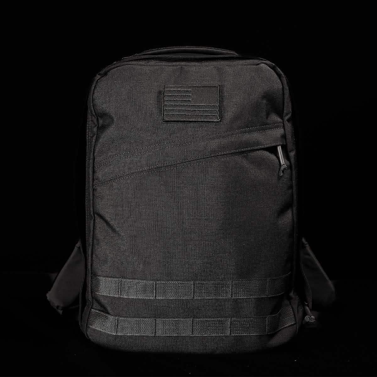 Black tactical GORUCK backpack with American flag patch and MOLLE webbing on front
