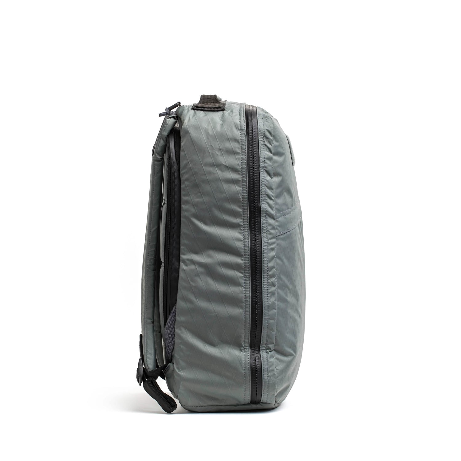 Side view of a gray durable GORUCK rucksack with black zippers on white background