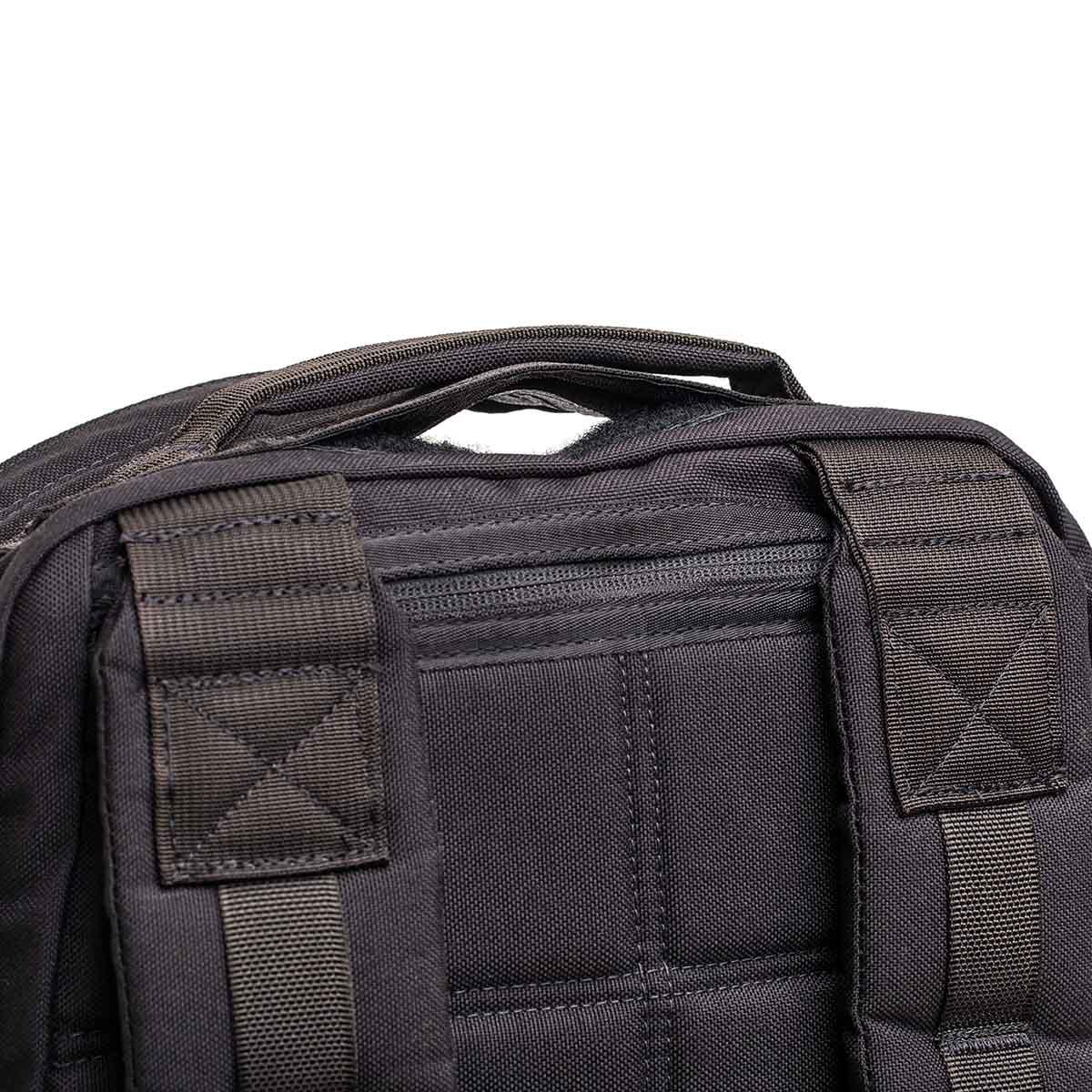 Close-up of durable black GORUCK backpack straps and top handle with rugged stitching detail