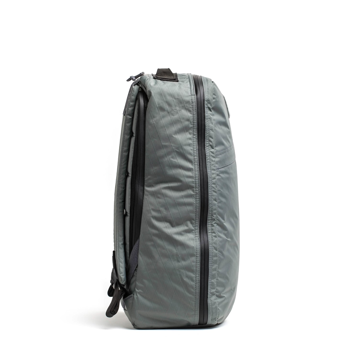Side view of a lightweight gray tactical rucksack with black zippers and padded back panel, designed for tough rucking gear