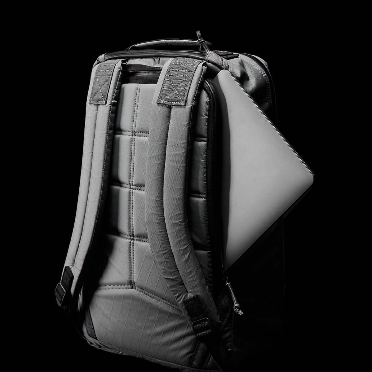 GORUCK rugged backpack with padded straps and a laptop partially inserted in the side zipper pocket