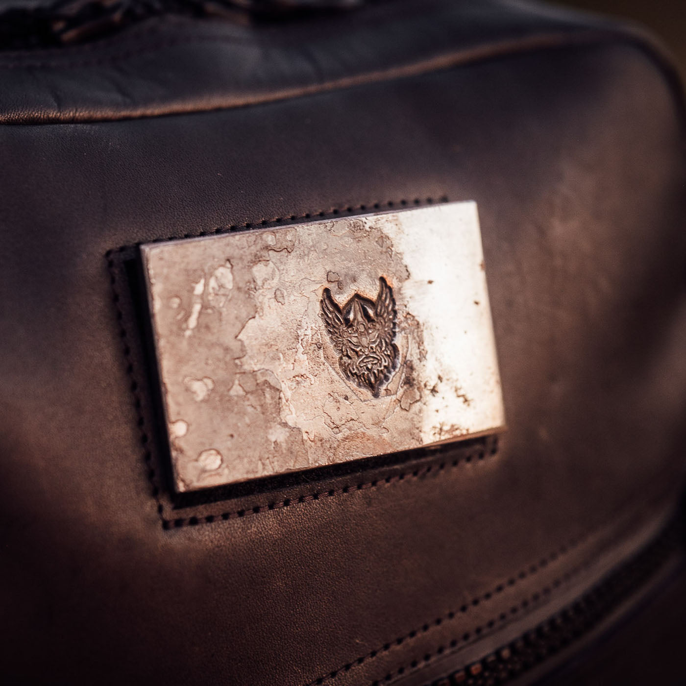 The GR1 USA x Carryology - Berserker Viking features a metal wolf head badge inspired by Viking armor, displayed on black leather—perfect for your bag or jacket.