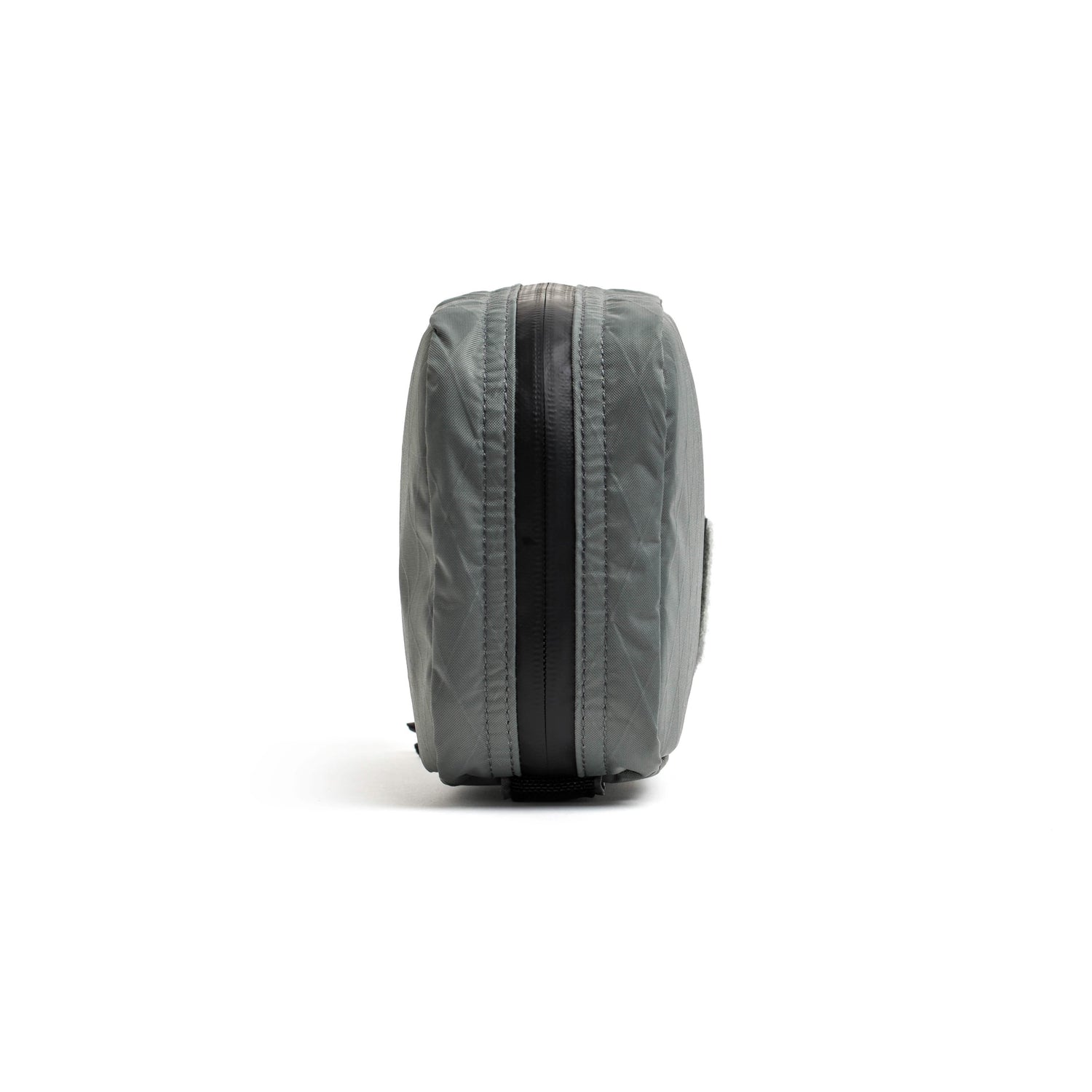 Side view of GORUCK Field Pocket in charcoal gray with black zipper against white background