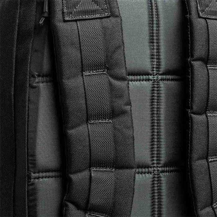 Close-up of black padded backpack straps and a quilted, cushioned back panel.