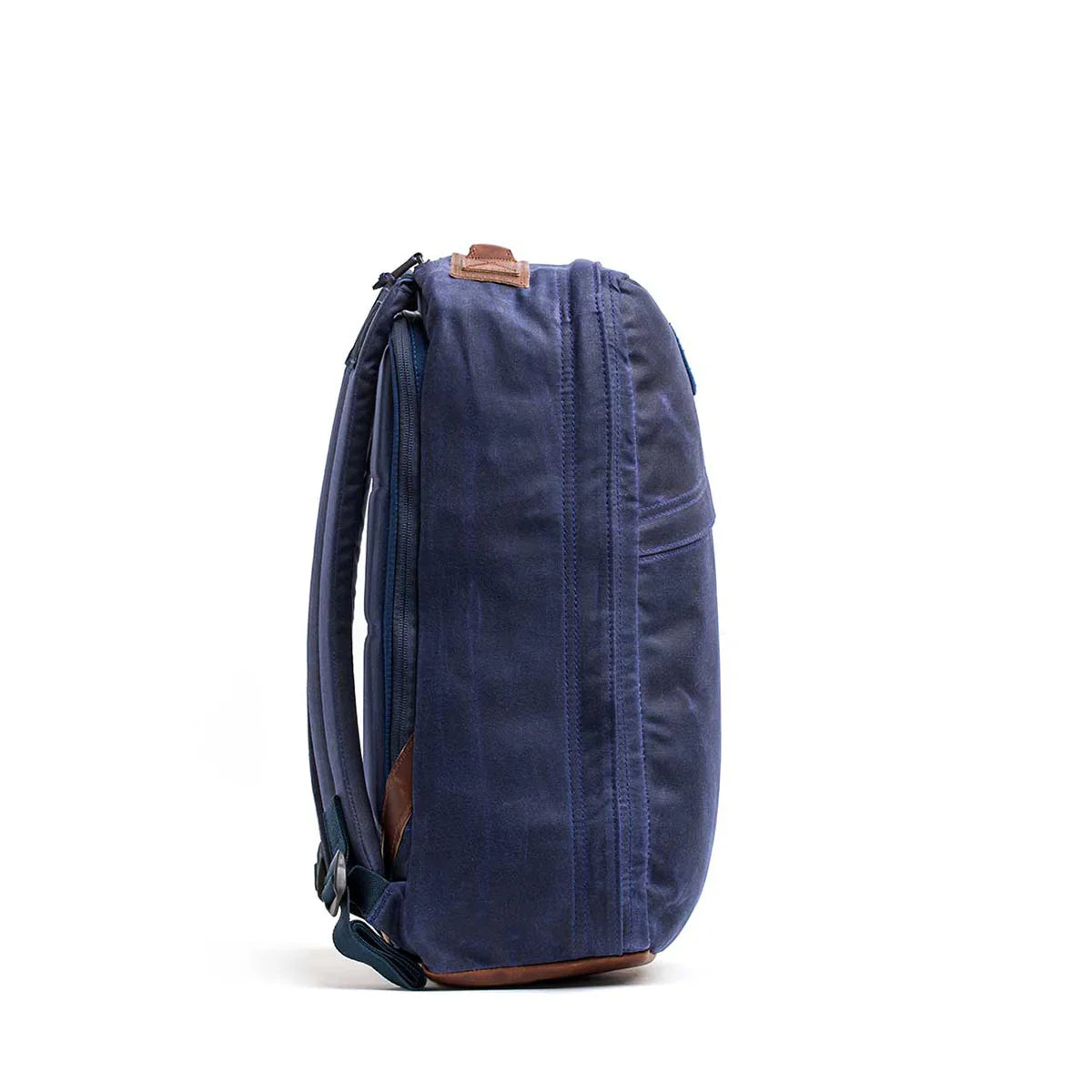 Side view of navy blue GORUCK Heritage rucksack with padded straps and leather accents on white background