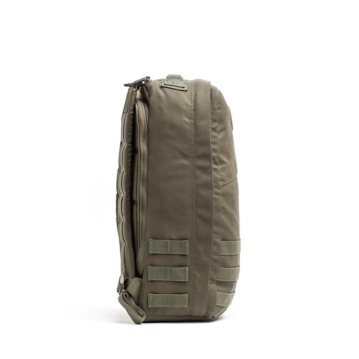Side view of the olive green GR1 USA - Ballistic Nylon Cordura (The Original Ruck) 210D Back Panel, featuring MOLLE webbing and a top zipper—ideal as a Special Forces-inspired everyday carry backpack, shown on a white background.