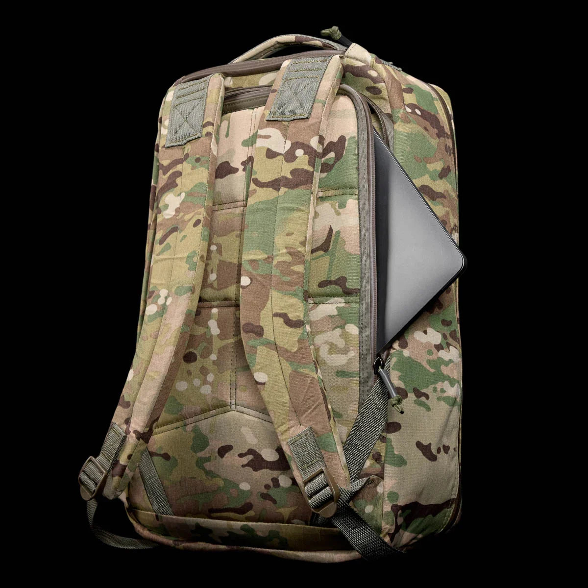 GORUCK multicam tactical backpack with padded straps and a laptop partially inserted in side compartment