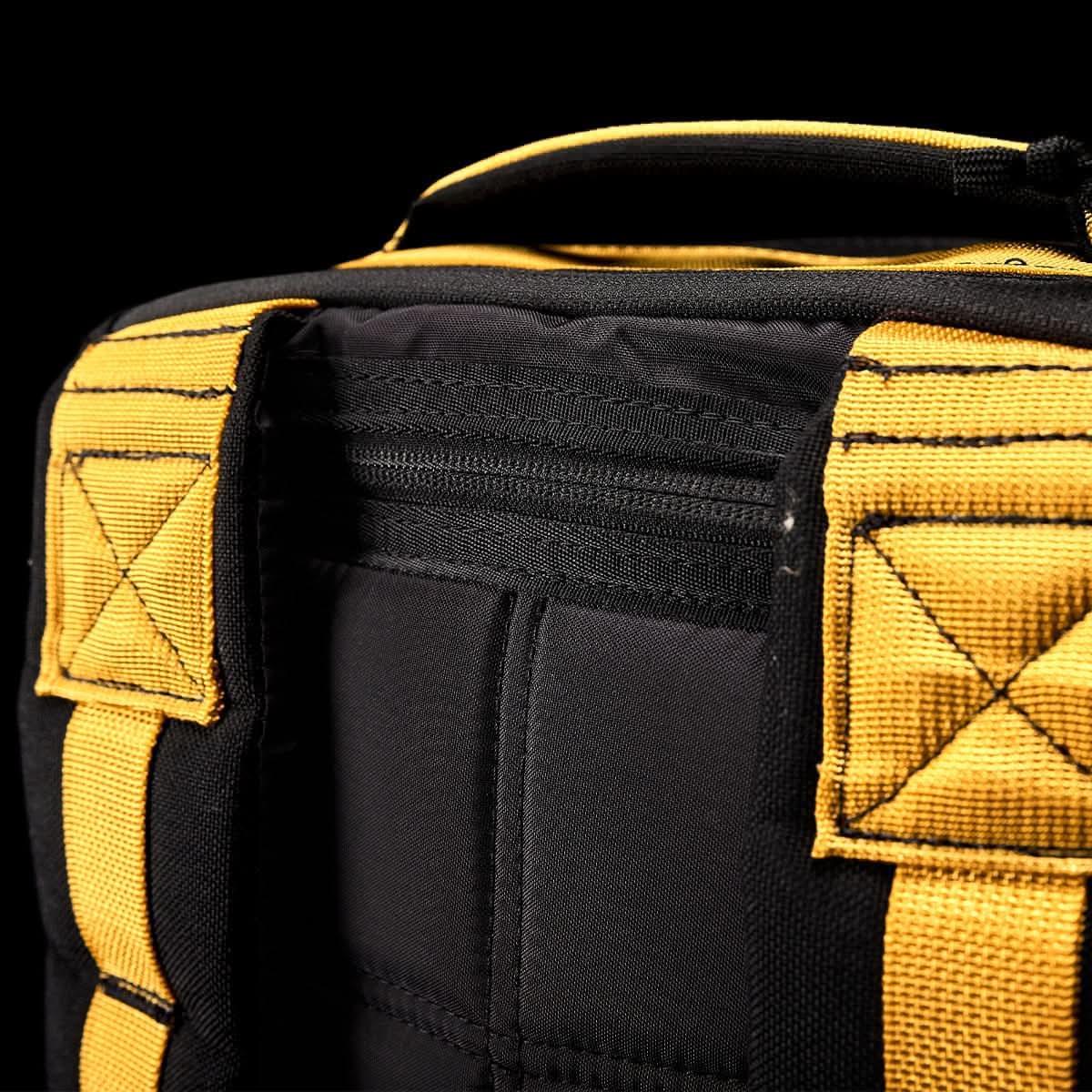 Close-up of black and gold GORUCK rucksack strap stitching and padded back panel detail