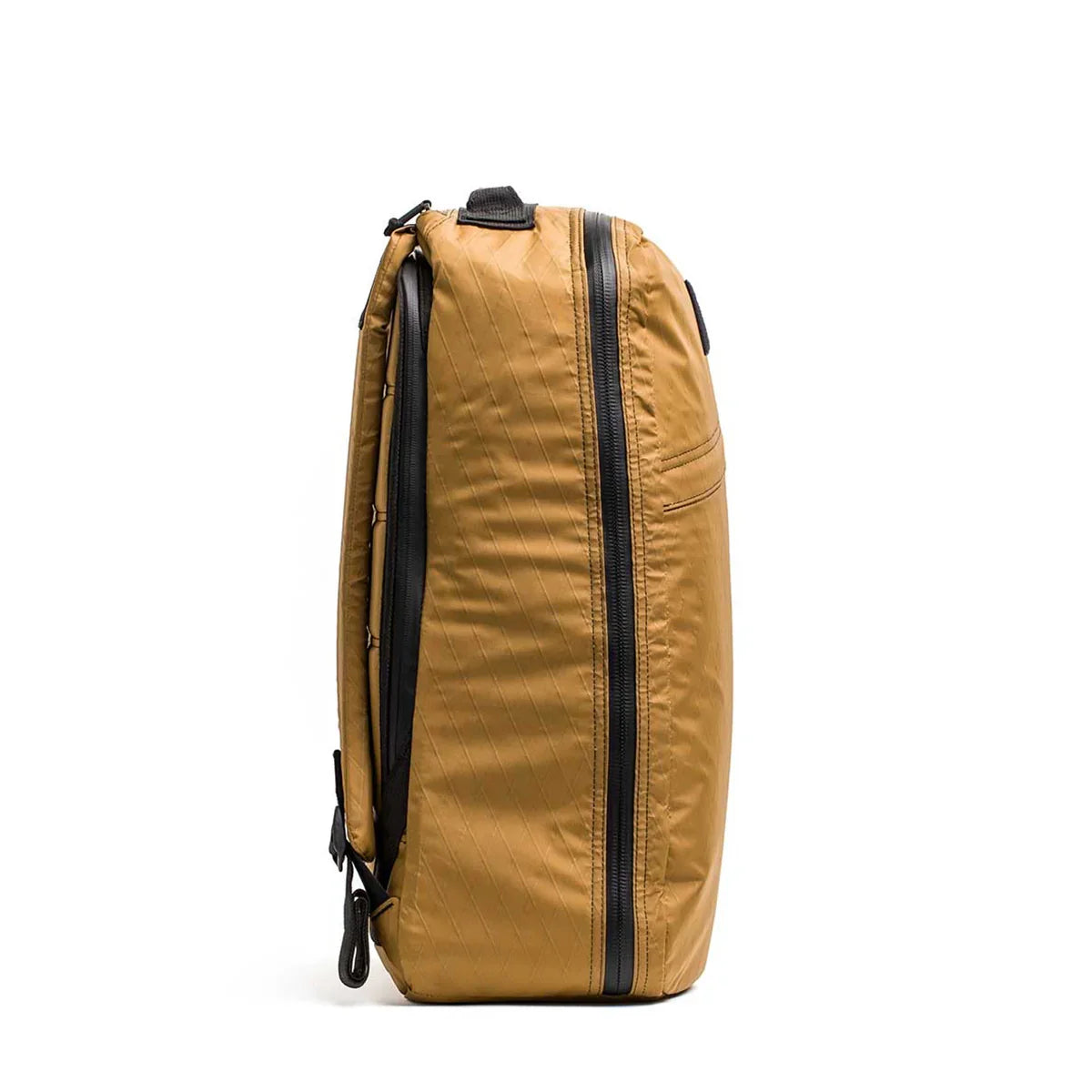 Side view of coyote brown GORUCK GR1 26L rucksack with black zippers on white background