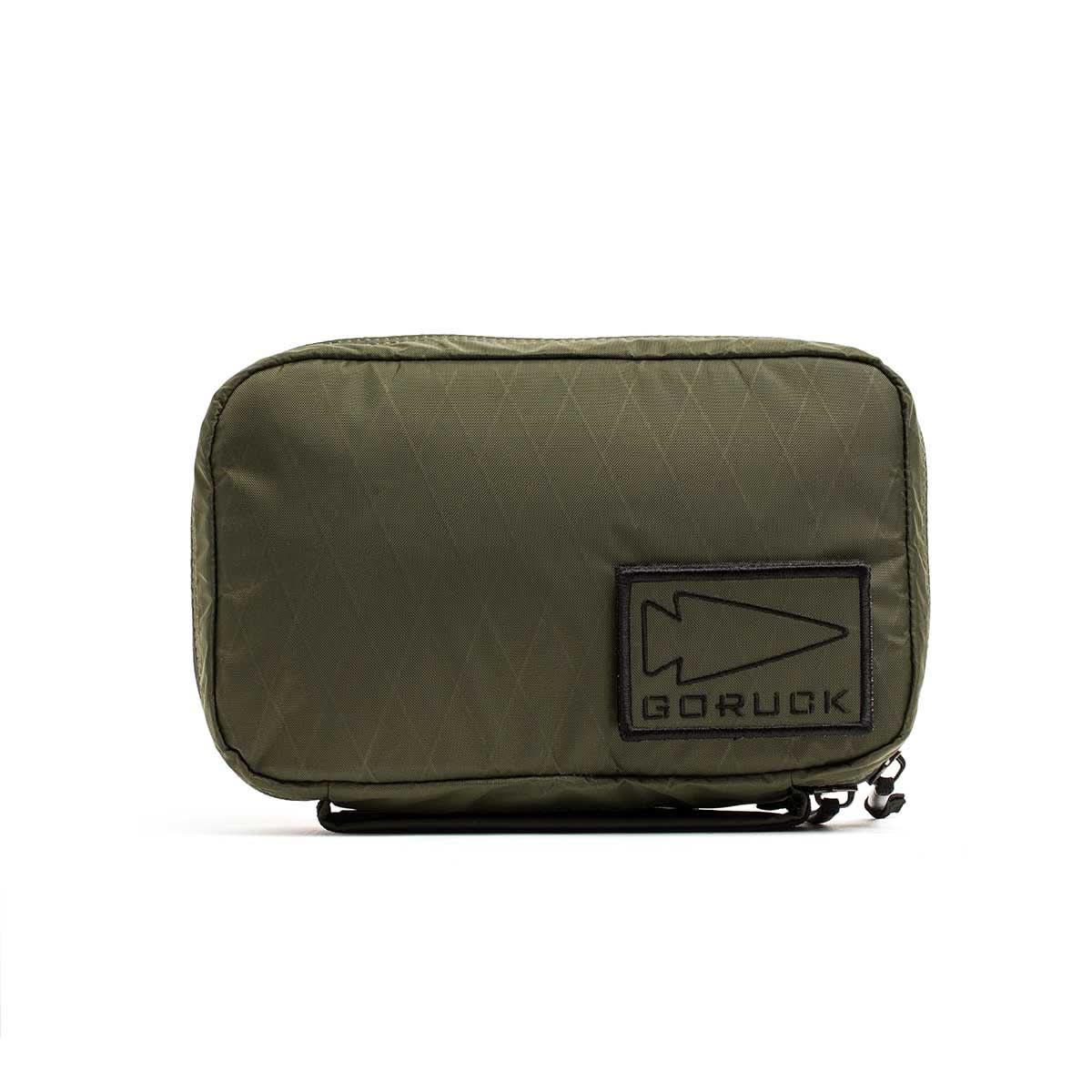 The GR1 Field Pocket - X-PAC is an olive green, waterproof zippered pouch with a GORUCK arrowhead patch—ideal as an electronics organizer.