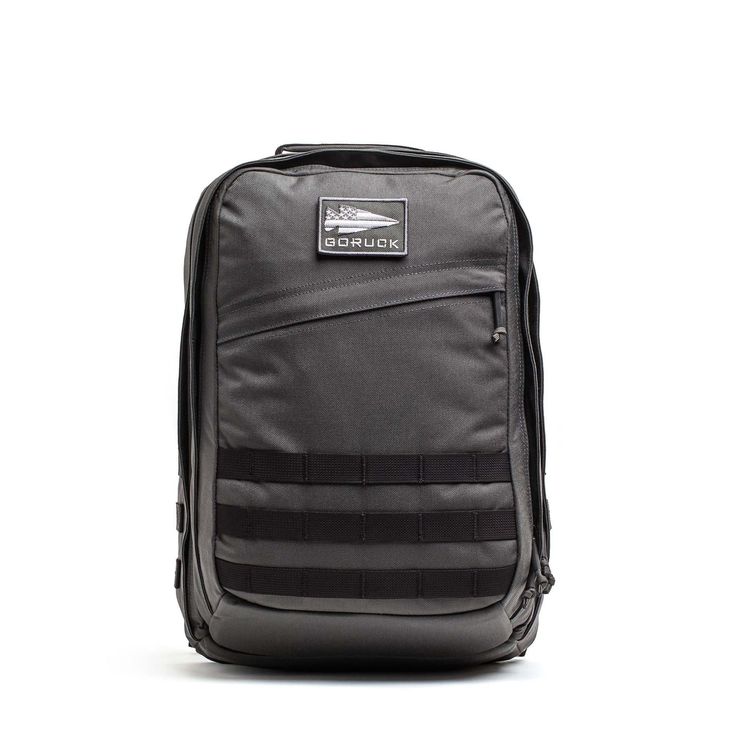 A black GR2 - Cordura ruck backpack with a front zipper pocket and horizontal webbing straps, designed for carry-on travel, is shown on a white background.