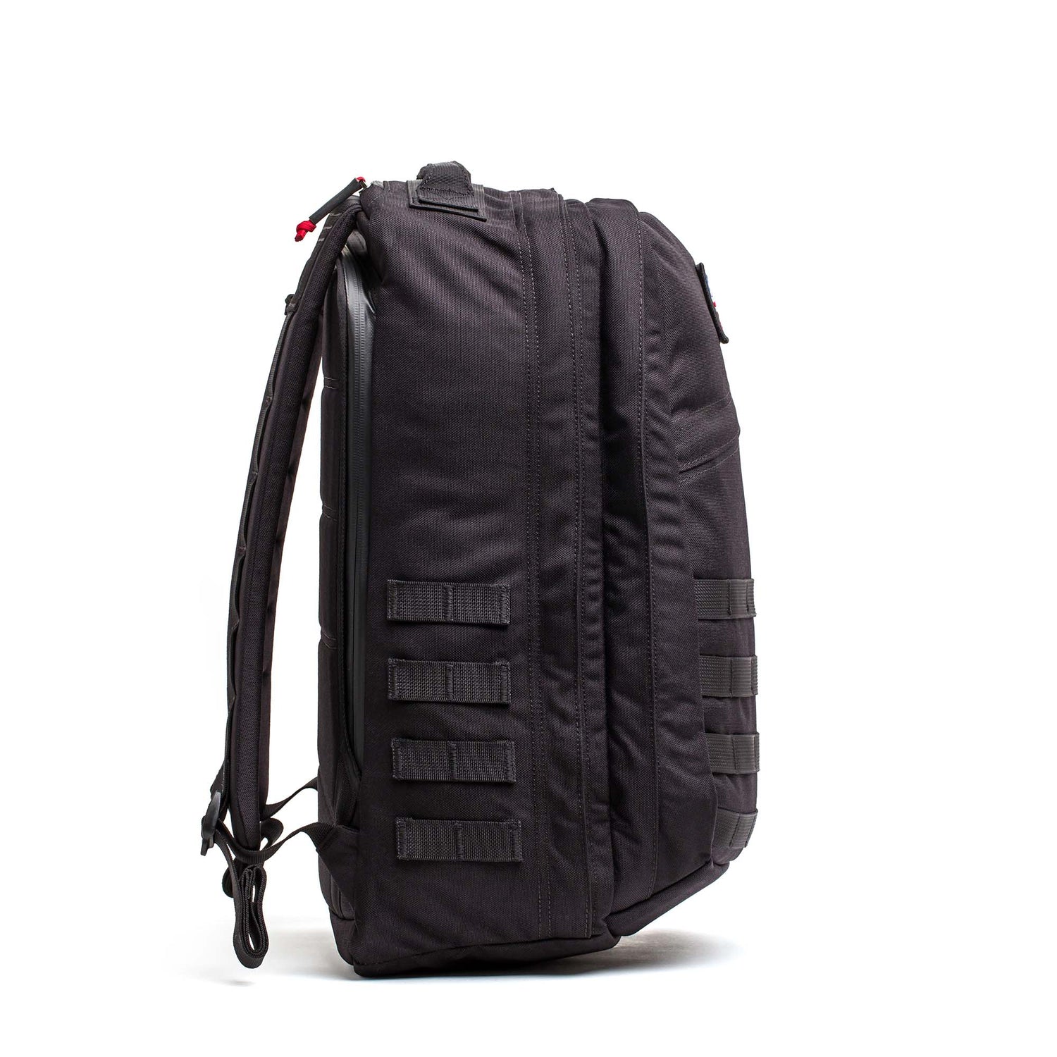 Side view of a black GR2 - Cordura backpack standing upright, featuring multiple horizontal straps and padded shoulder straps—ideal as a rugged carry-on travel bag.