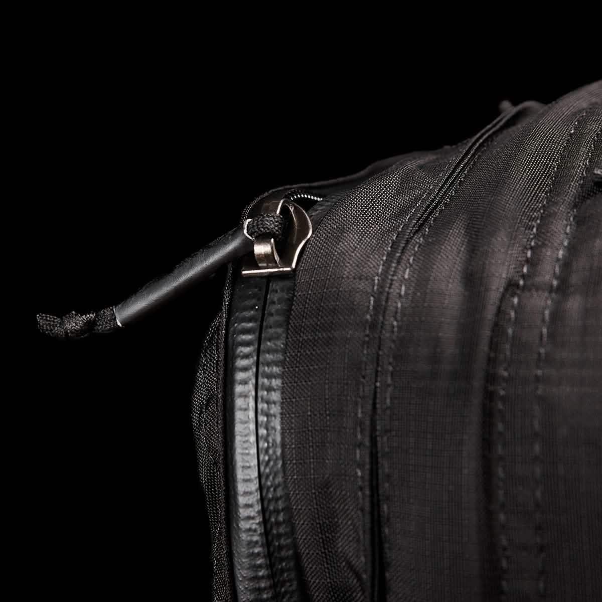 Close-up of GORUCK black rucksack zipper with durable Robic fabric on a black background