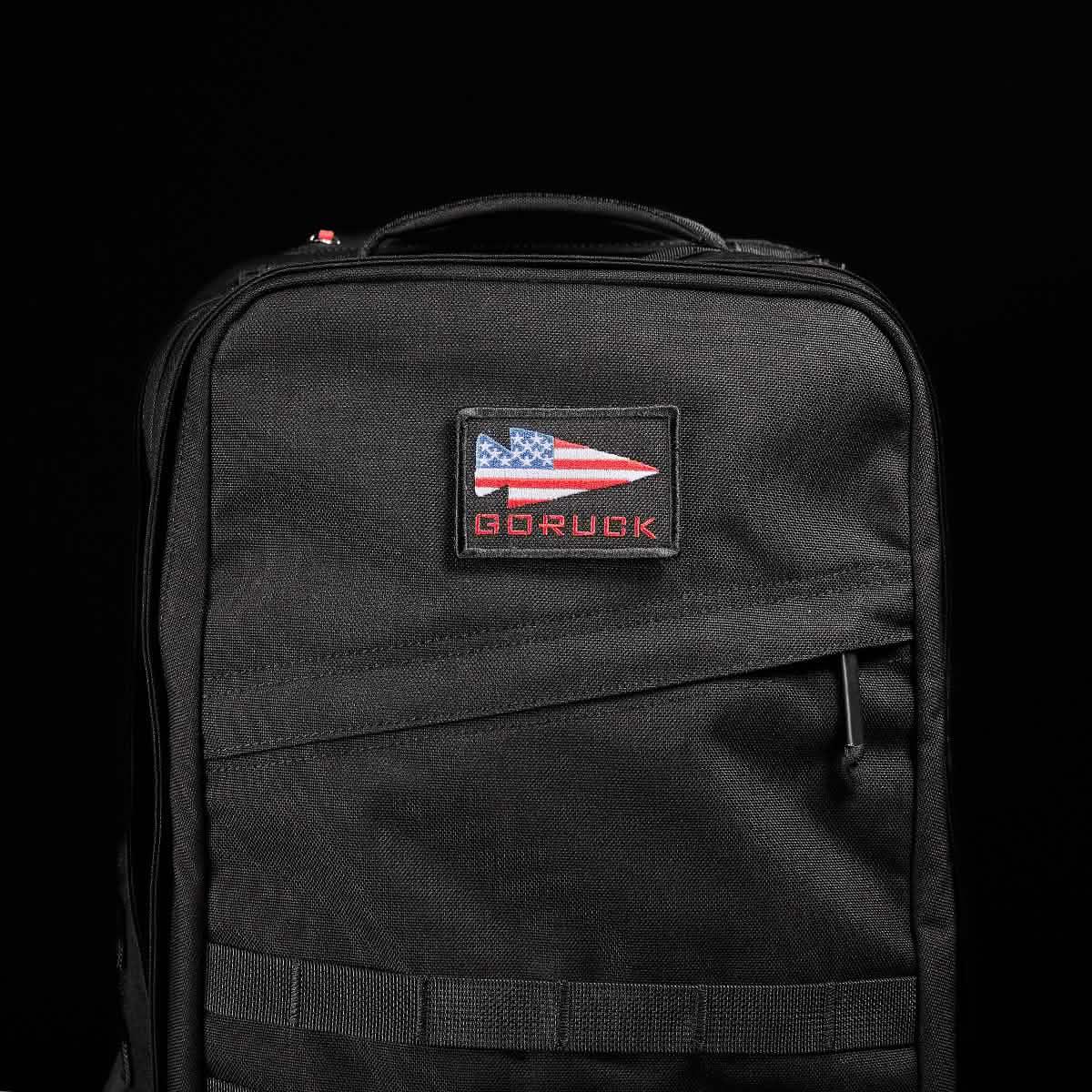 Black GORUCK backpack with American flag logo patch on front against black background