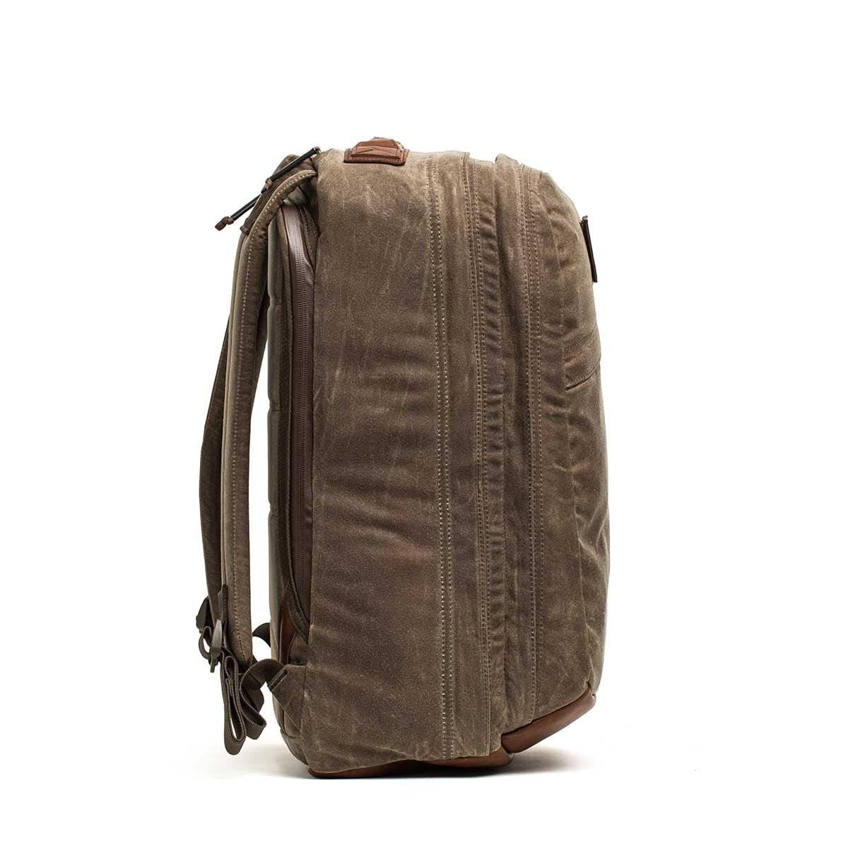 Side view of GORUCK Heritage Dark Oak waxed canvas rucksack with leather accents on white background