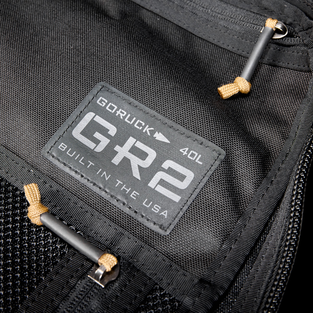 Close-up of a black GR2 USA Throwback travel backpack, crafted from rugged 1000D Cordura, featuring a