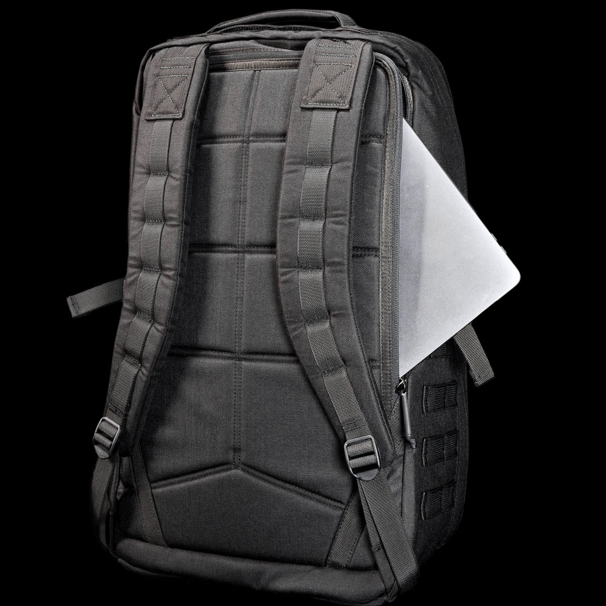 The GR2 USA Throwback is a black travel backpack made of rugged 1000D Cordura, with padded straps and a silver laptop in the back zipper pocket—ideal for daily use or adventure.