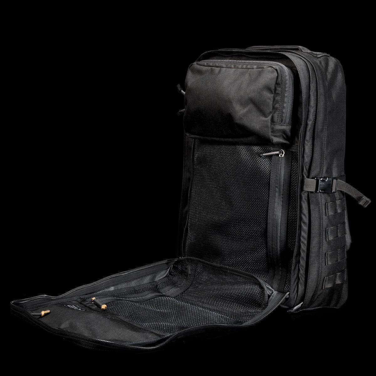 The GR2 USA Throwback is a black travel backpack with multiple compartments, shown open to reveal mesh pockets inside, set against a black background. Made from rugged 1000D Cordura and inspired by the original GR2 design.