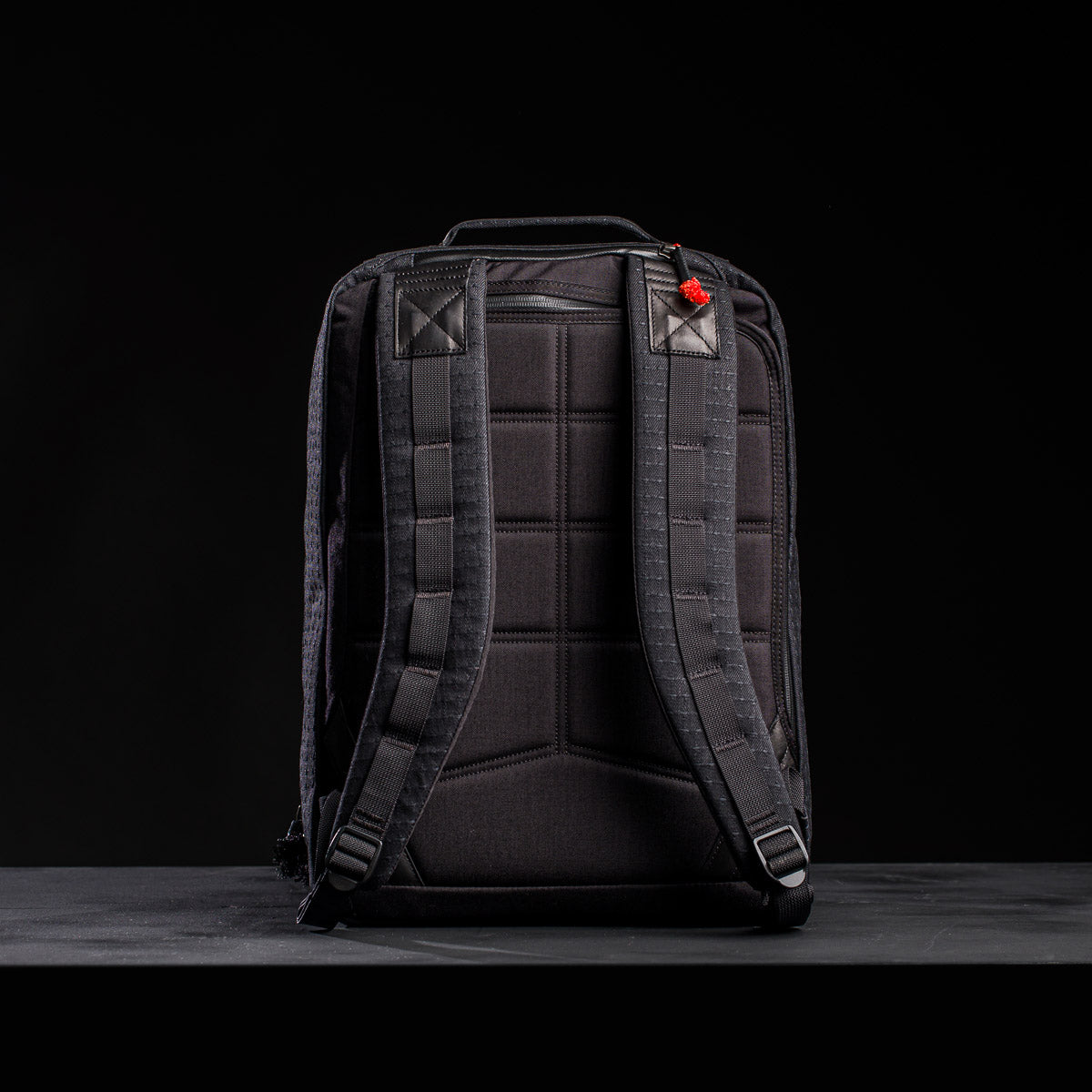 The GR2 x Carryology - GRXC2 Samurai 2.0 backpack, crafted from JPXDP denim in a Japan Blue collaboration with padded shoulder straps, is shown against a dark background.