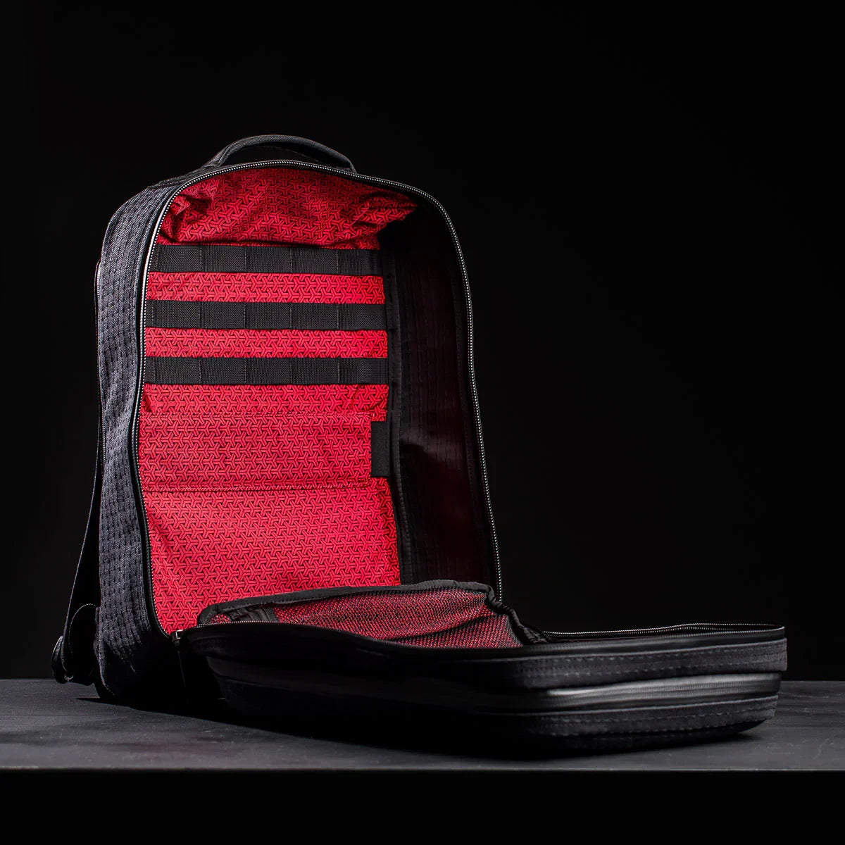 Open black GORUCK GR2 26L backpack showing red interior with MOLLE webbing and mesh pockets