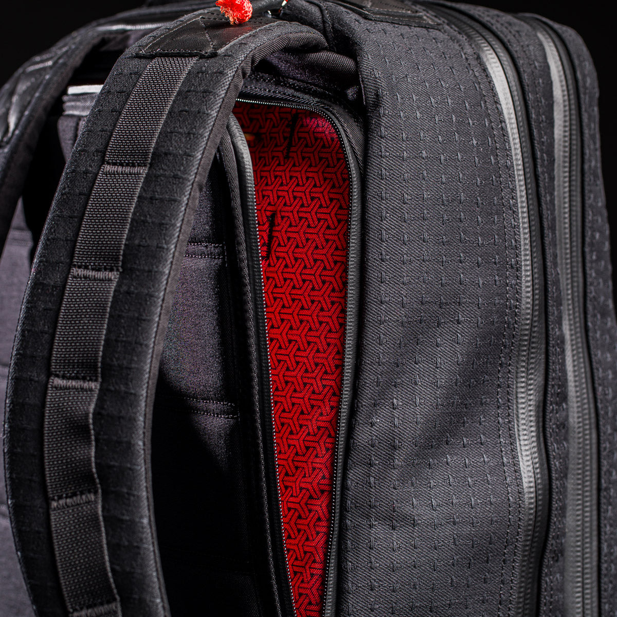 Close-up of the GR2 x Carryology - GRXC2 Samurai 2.0 backpack, featuring padded straps and a red geometric-patterned interior, crafted from Black Samurai Sashiko fabric in the exclusive Japan Blue collaboration.