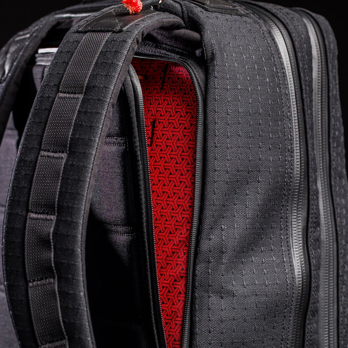 Close-up of the GR2 x Carryology - GRXC2 Samurai 2.0 backpack, featuring padded straps and a red geometric-patterned interior, crafted from Black Samurai Sashiko fabric in the exclusive Japan Blue collaboration.
