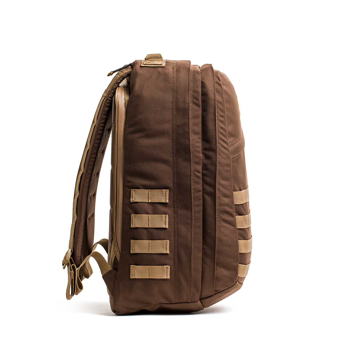 The GR2 - Ballistic Nylon Cordura is a brown travel bag with tan straps and side webbing, shown from the side on a white background. This ruck is carry-on compliant for convenient trips.