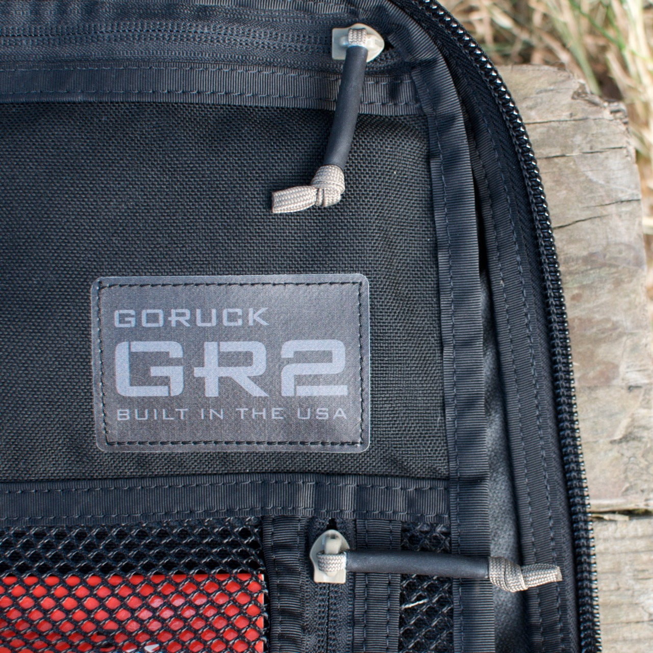 Close-up of a black GR2 USA - Cordura ruck, showing its label and zipper outdoors—the ideal carry-on backpack inspired by Special Forces gear.