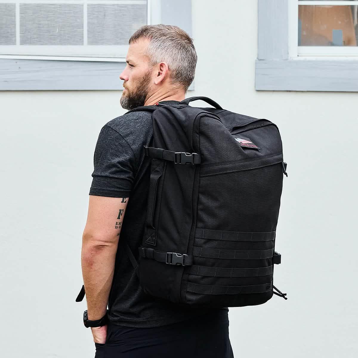 Man wearing a black GORUCK backpack outdoors, showcasing rugged rucking gear design.
