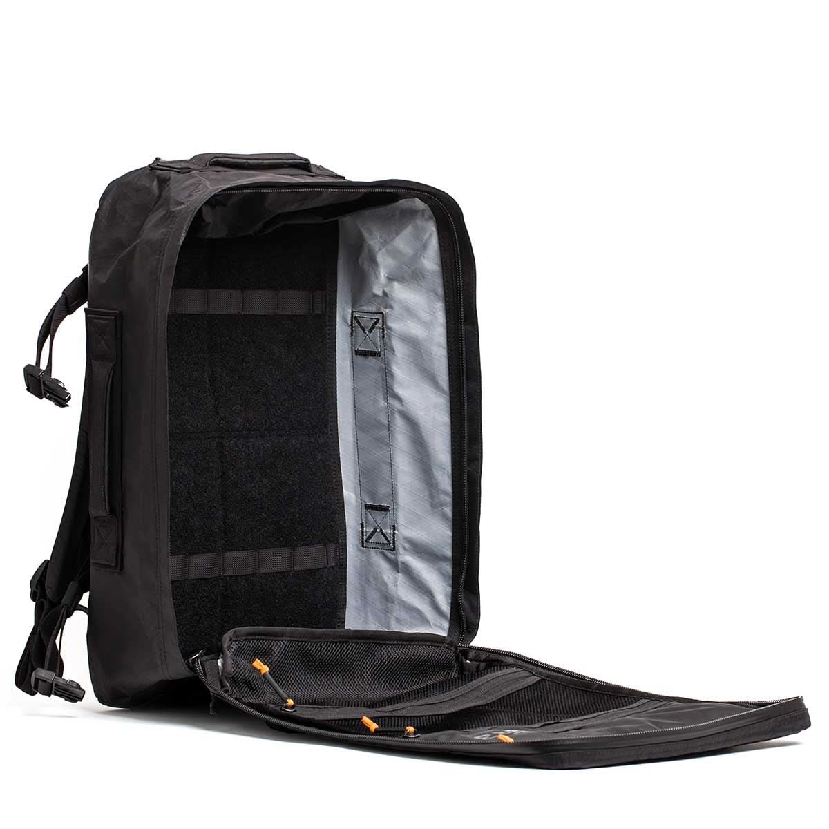 The GR3 - X-PAC carry-on backpack is open, showcasing its roomy interior and mesh pocket inside the flap, all made from waterproof material.