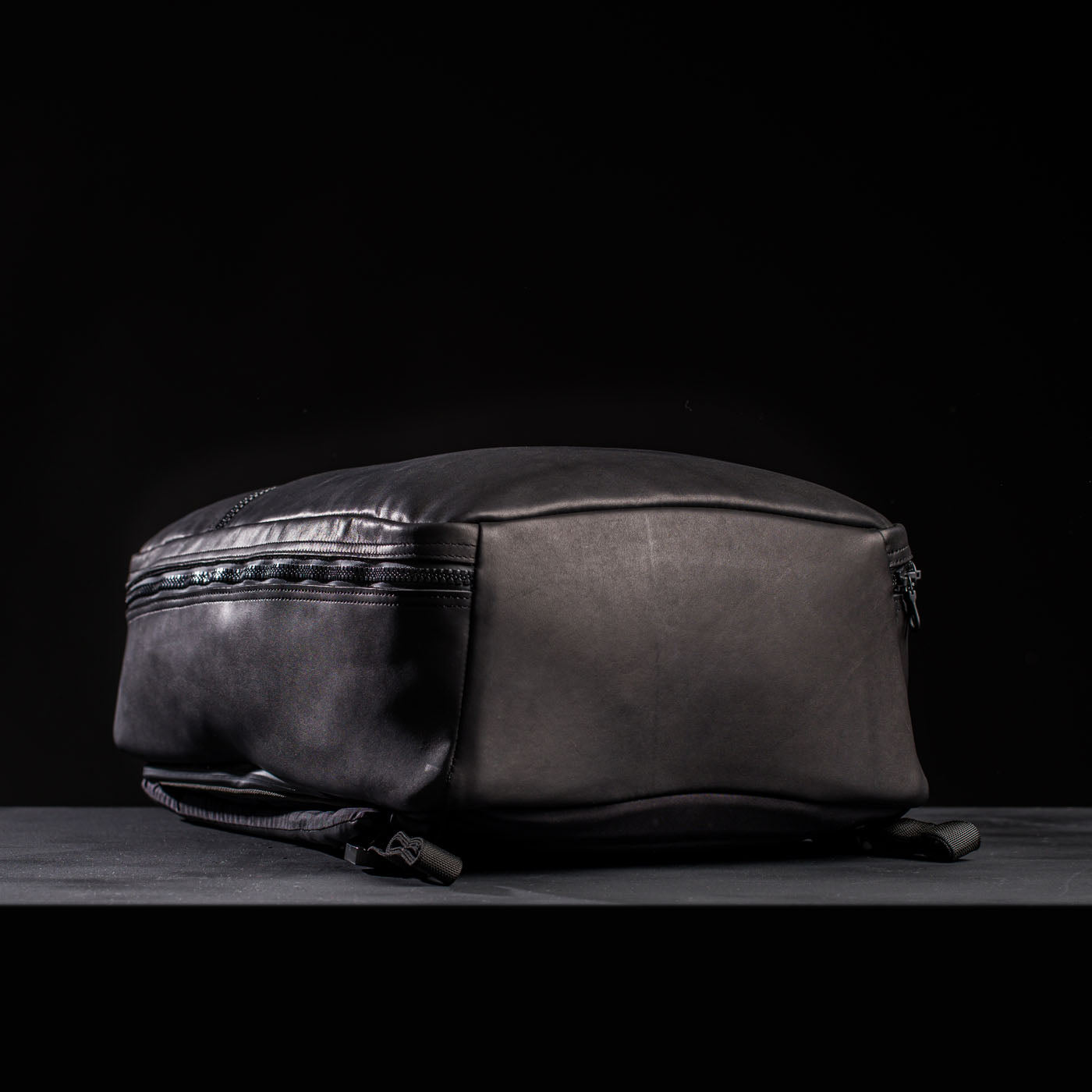 The GR1 USA x Carryology - Berserker Viking backpack lies flat on a dark surface with a black background, inspired by the rugged spirit of Viking Berserkers.