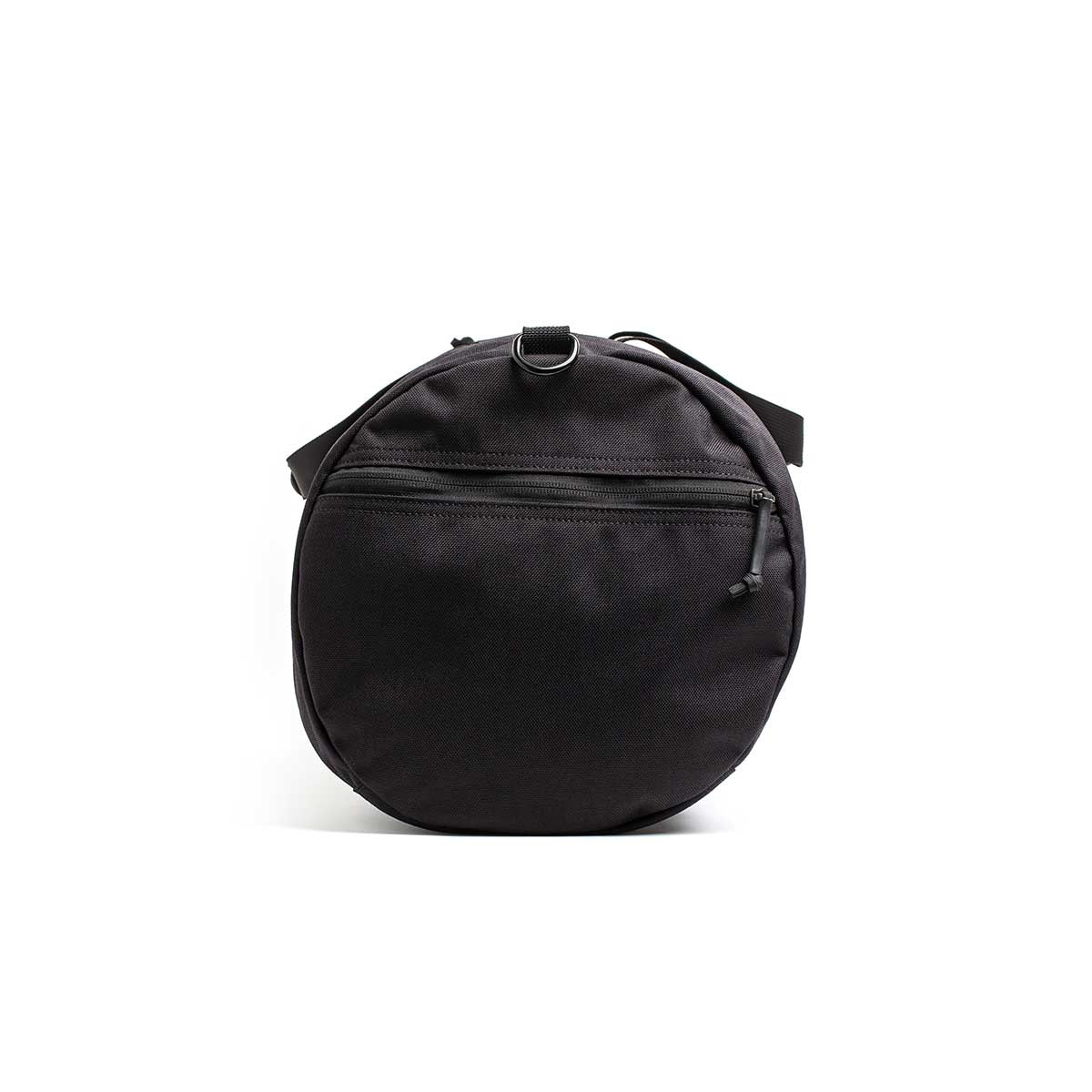 The Gym Bag - Cordura is a round black shoulder bag made from durable 1000D CORDURA, featuring a front zipper pocket and a small top strap, displayed against a white background.
