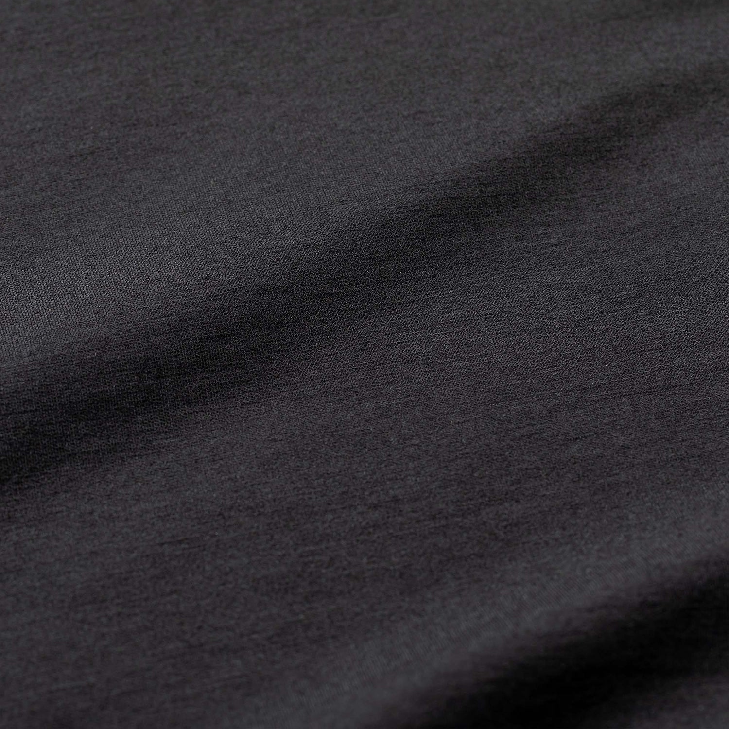 Close-up of the Men's Heavy Commando Quarter Zip - Merino Wool in dark gray, showing its smooth texture and gentle, soft folds.