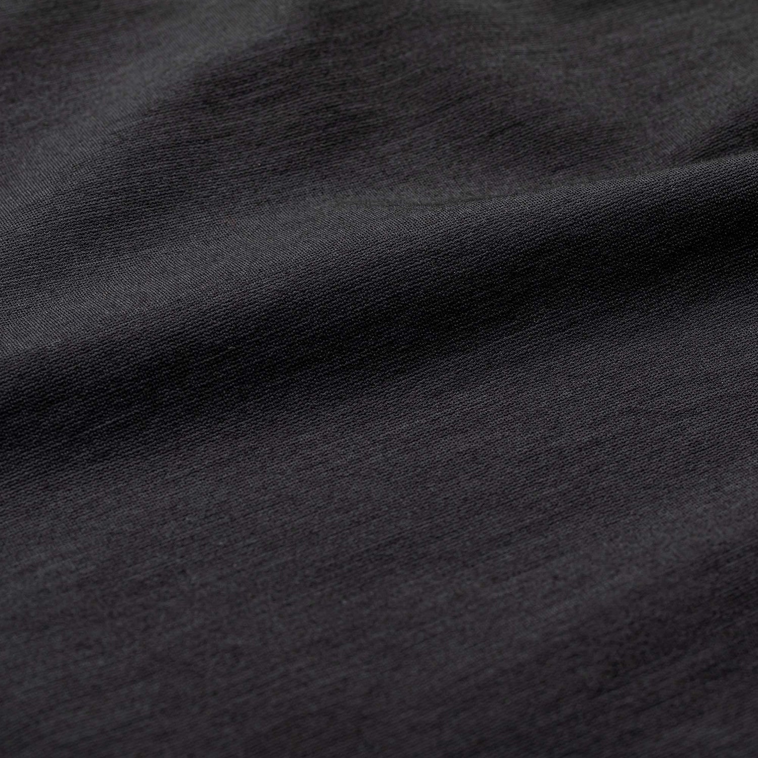 Close-up of the Heavy Commando Shirt - Merino Wool in dark grey, showing its subtly textured fabric with slight folds and emphasizing its moisture-wicking and odor-resistant properties.