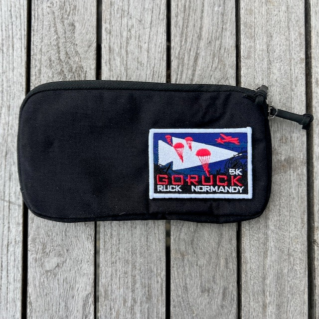 A Sternum Pouch - Cordura in black, shown on wood with a