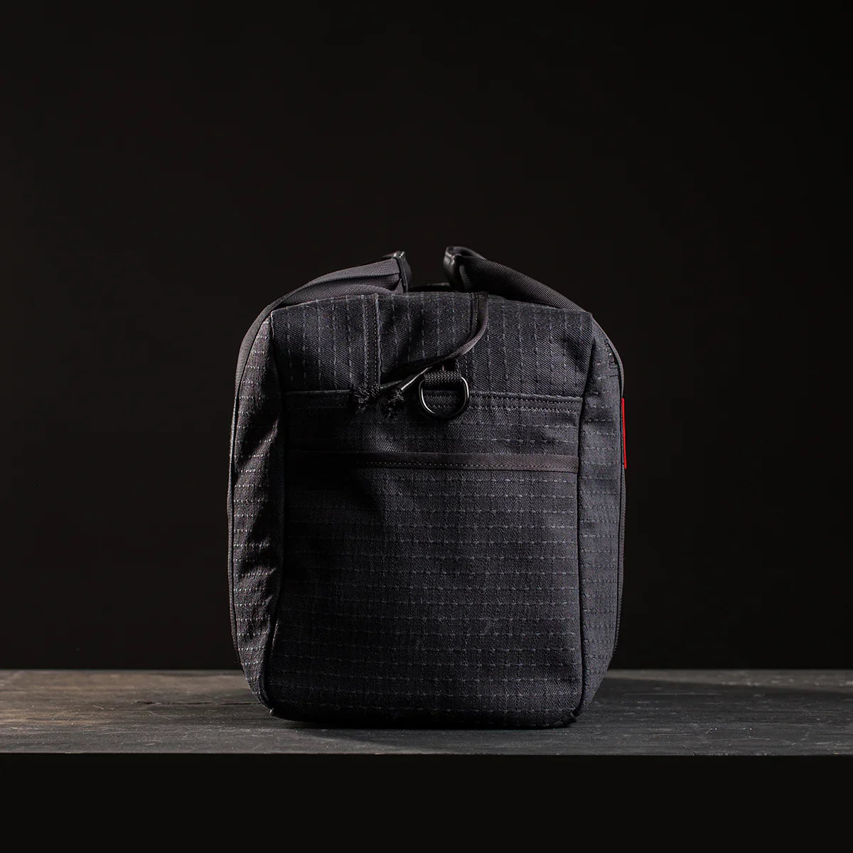Black GORUCK ruck sack standing upright on dark surface with subtle texture and minimalistic design
