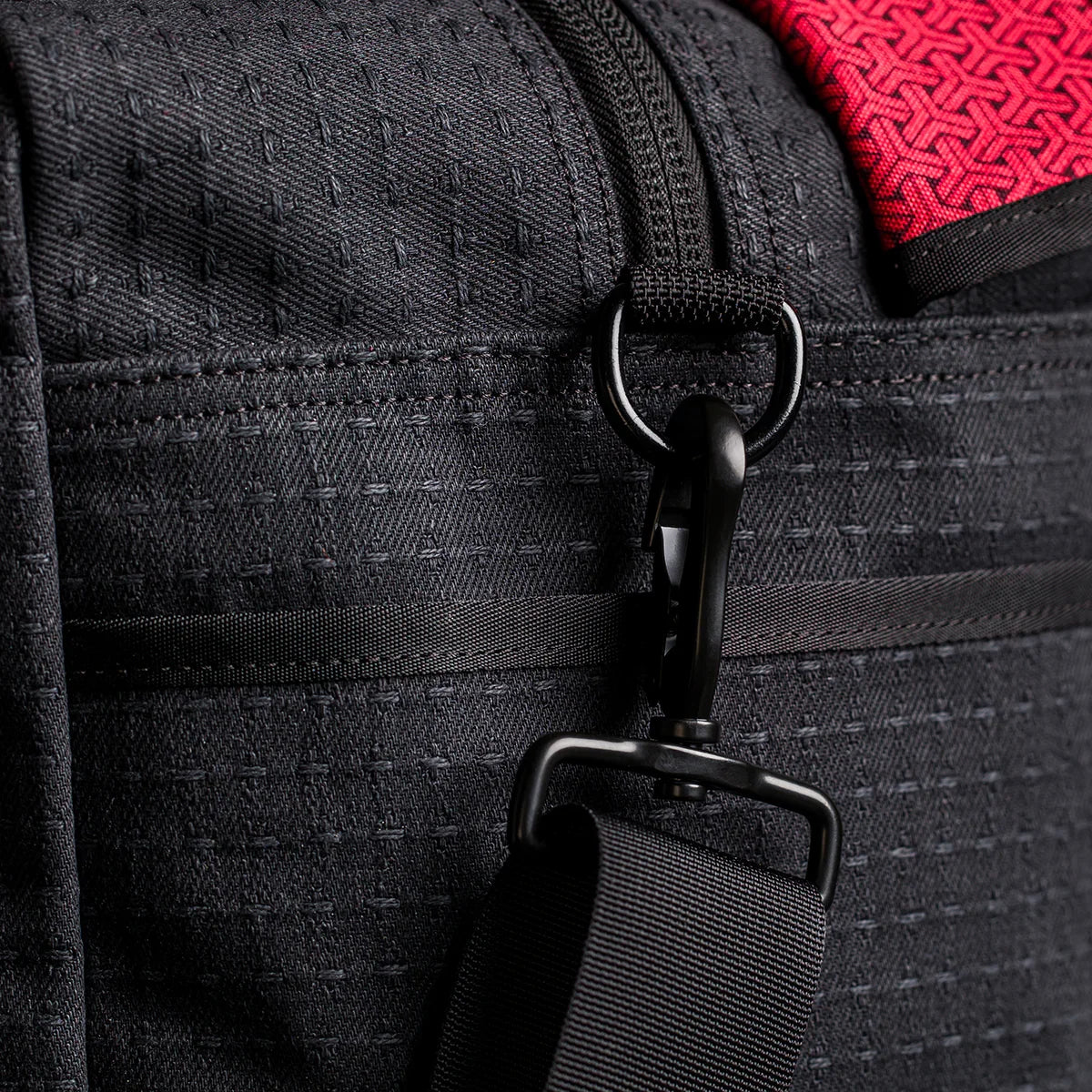Close-up of the Kit Bag x Carryology - GRXC2 Samurai 2.0 in black technical fabric, designed with a detachable shoulder strap and a red accent at the top.