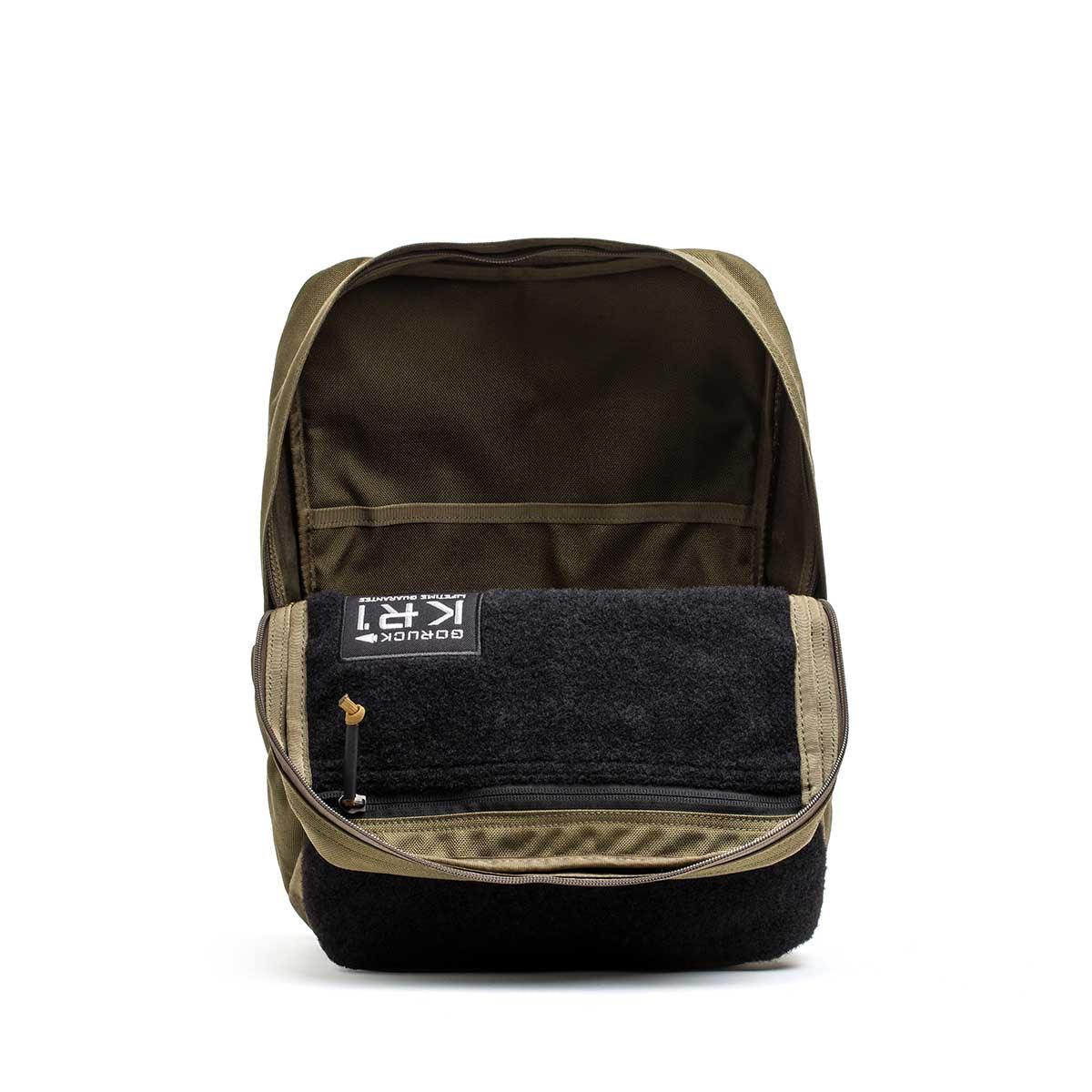 Open GORUCK Ranger Green and Coyote rucksack showing internal pockets and black front panel with logo