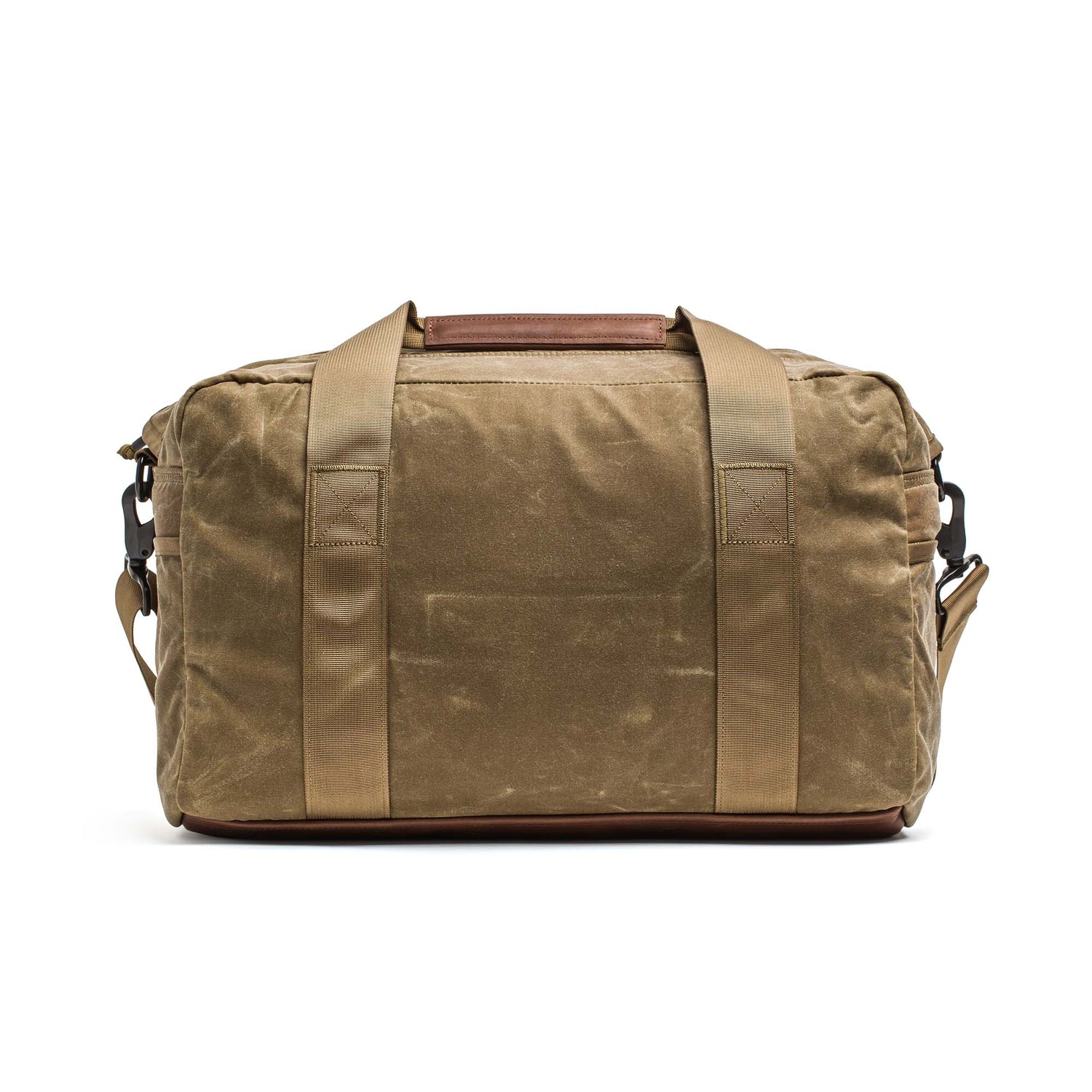 The Kit Bag - Waxed Canvas is a brown canvas duffel inspired by classic pilot flight bags, featuring tan handles and a detachable shoulder strap, displayed on a white background.