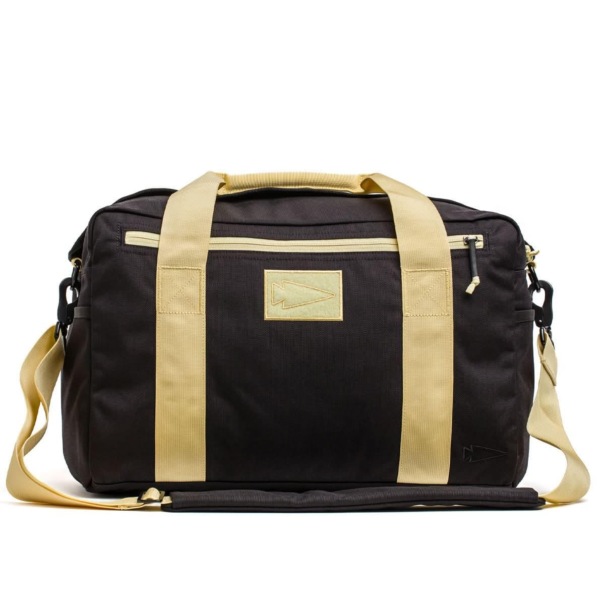 Black GORUCK Lead Kit Bag with gold handles, shoulder strap, and front zipper pocket, durable rucking gear