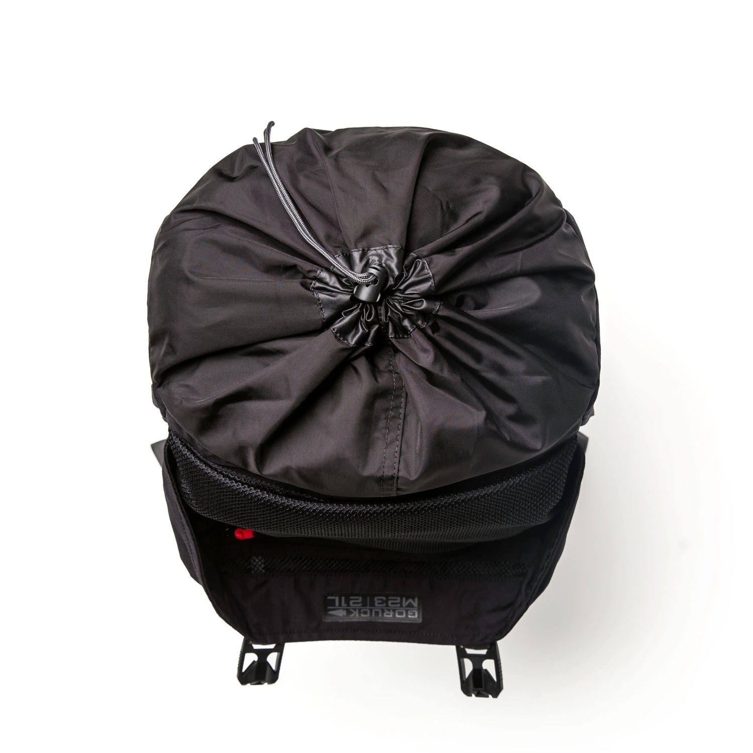 Top view of black GORUCK rucksack with drawstring closure and front buckle straps on white background