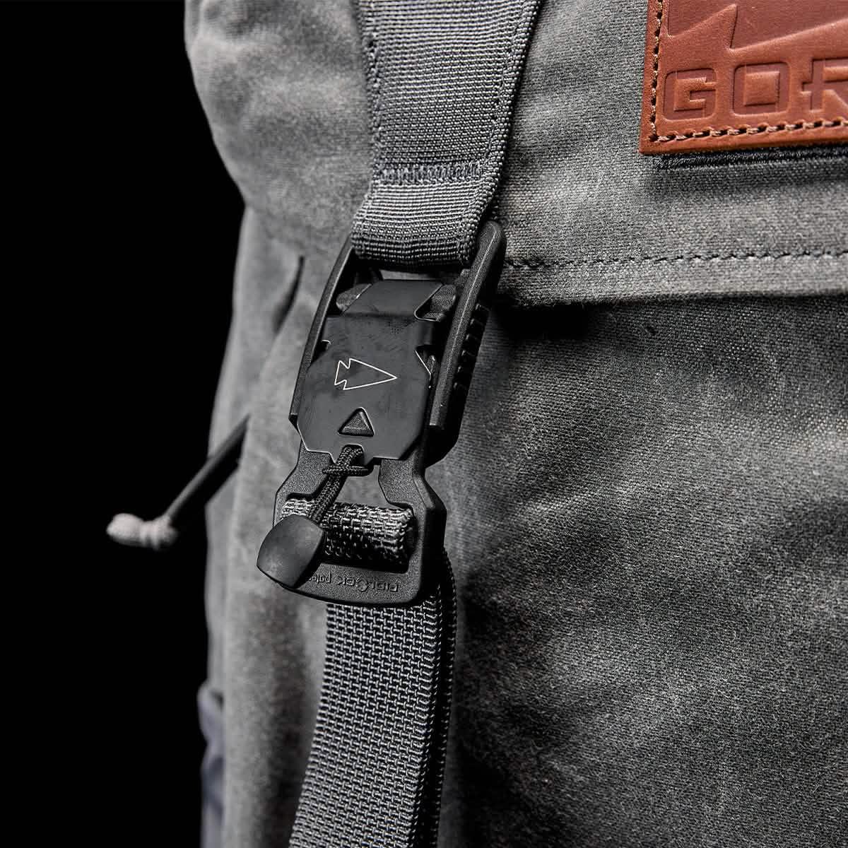 Closeup of GORUCK slate gray rucksack buckle and strap with leather logo patch
