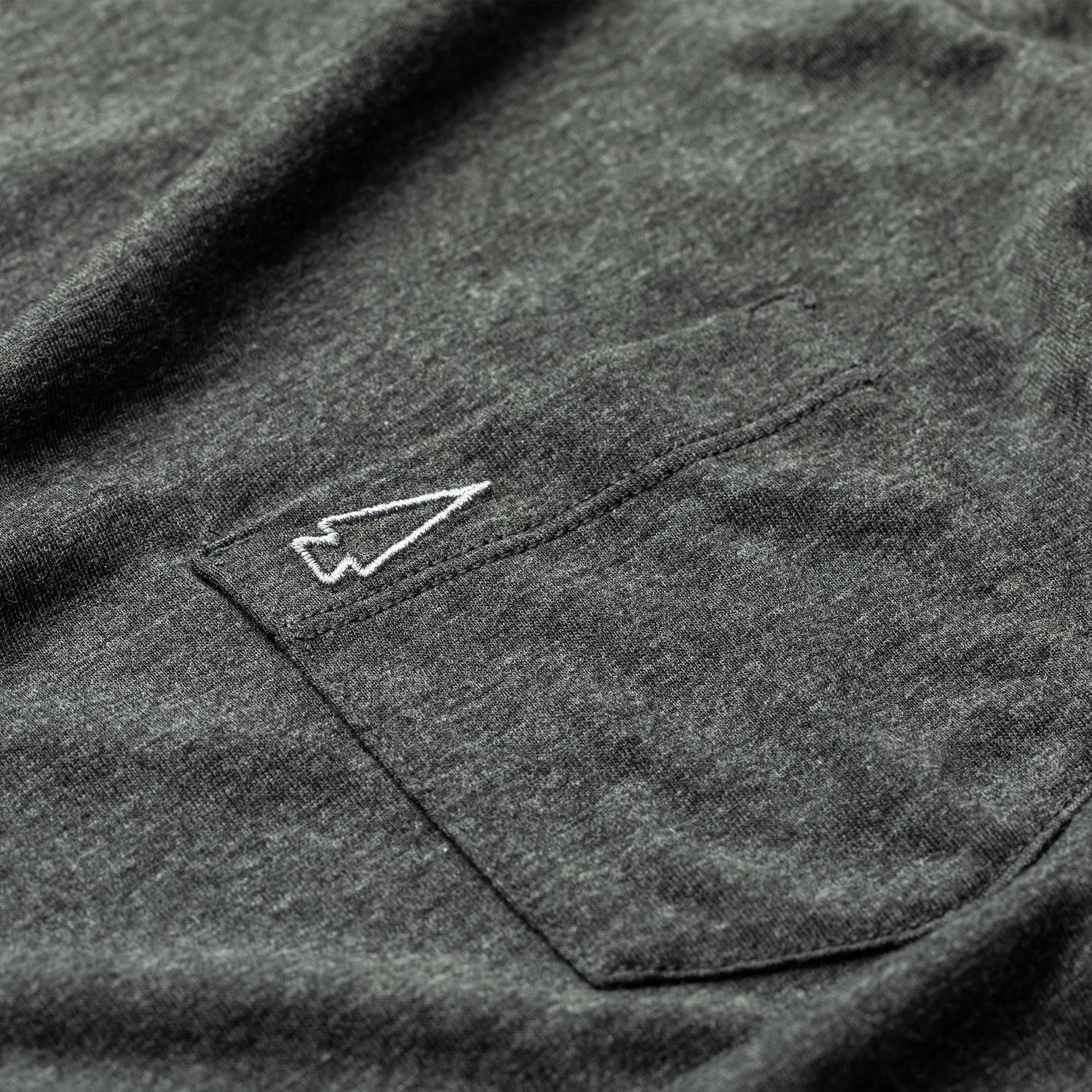 Close-up of the Men's Long Sleeve Pocket Tee - Tri-Blend in dark gray, showcasing its premium fabric and a pocket with an embroidered white arrowhead design.
