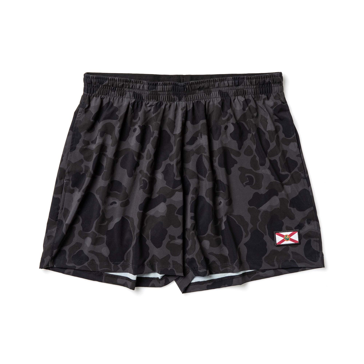 The Men’s USA Training Shorts - ToughStretch feature black camouflage, an elastic waistband, a red and white X flag patch, and are made from durable fabric for intense workouts.