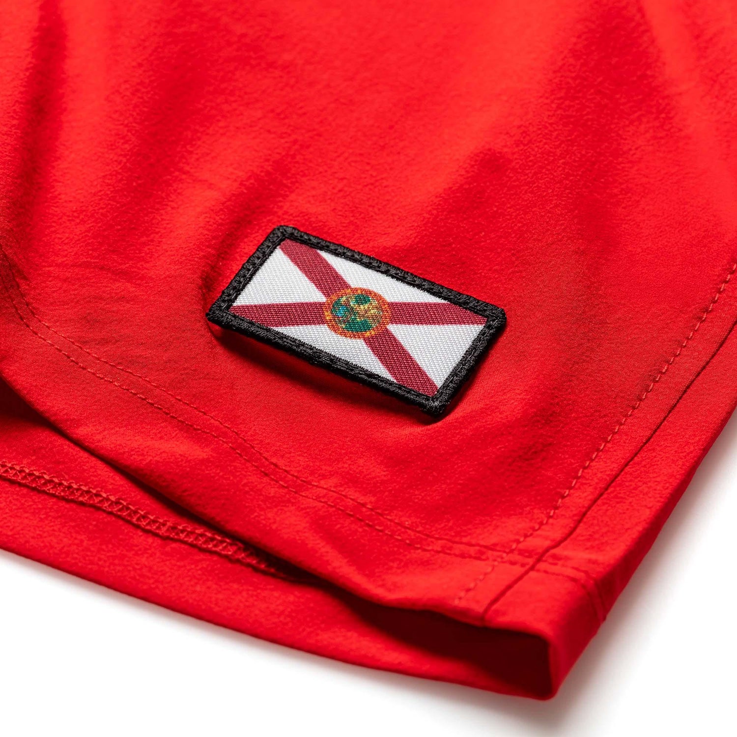 Close-up of red men's training shorts with Florida state flag patch and detailed stitching