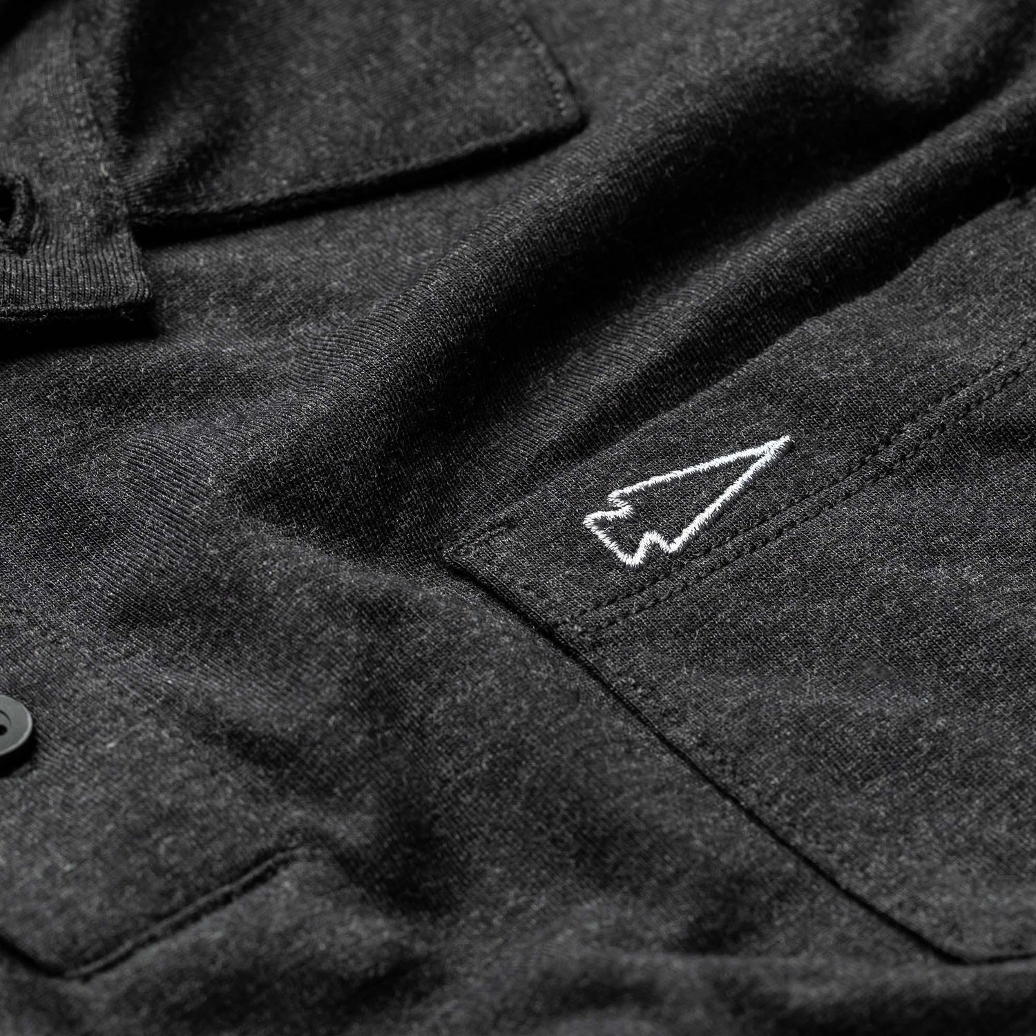 GORUCK men's black triblend polo with pocket and white spearhead embroidery close-up