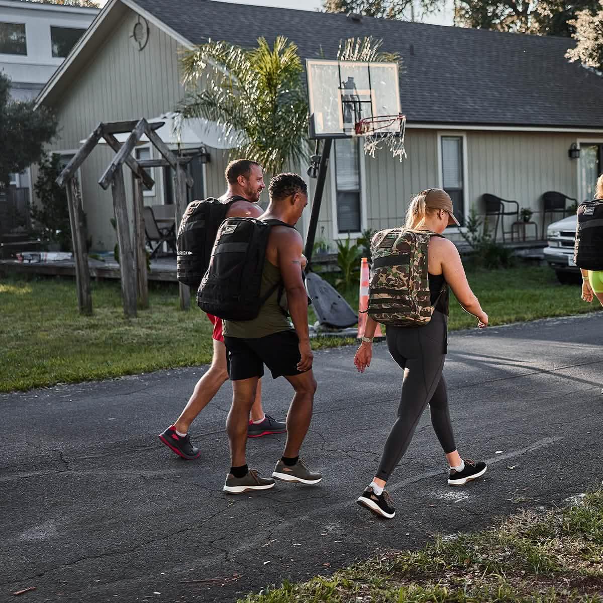Group rucking with GORUCK backpacks outdoors in a suburban neighborhood