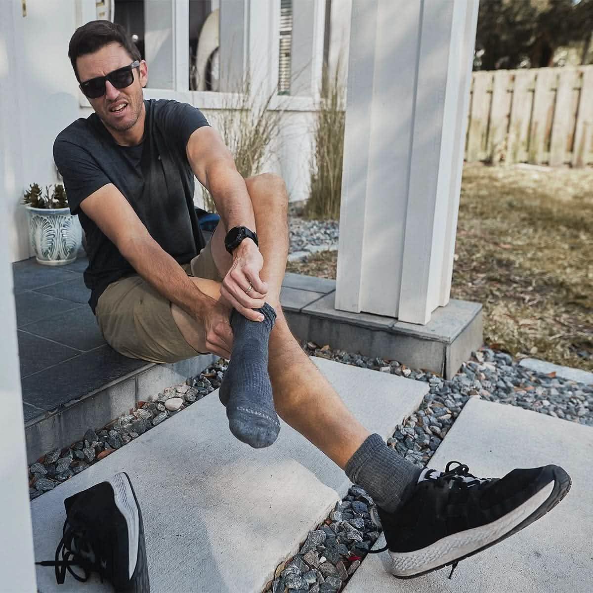 Man outdoors wearing GORUCK Merino wool charcoal grey socks and athletic shoes