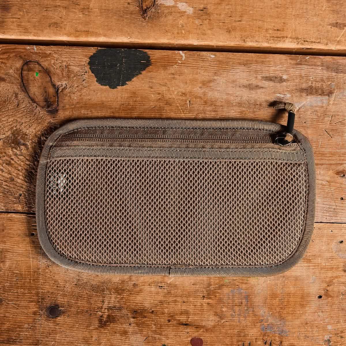 GORUCK coyote brown mesh zippered gear panel on rustic wooden surface